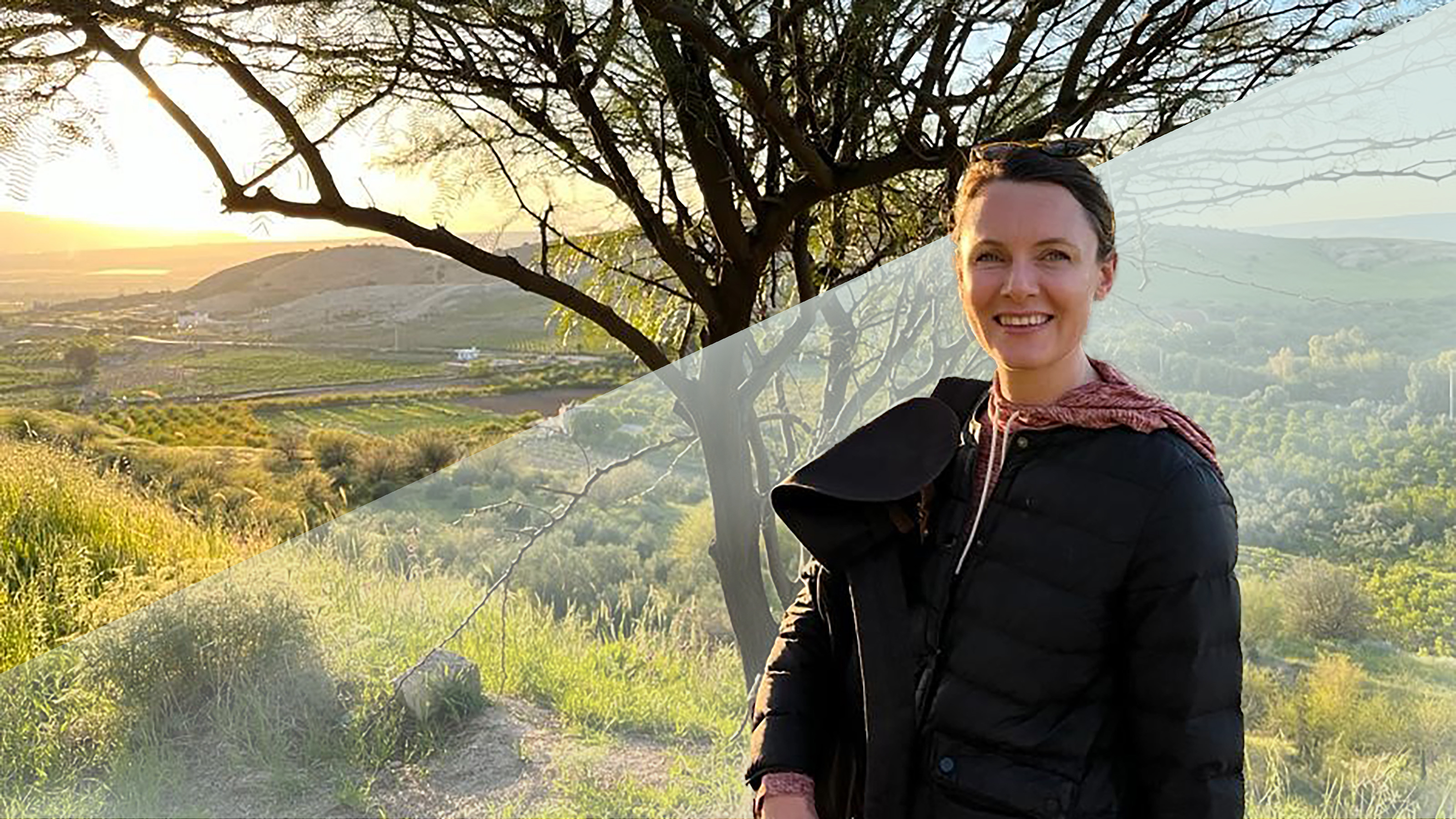 A woman in a black athletic jacket standing in front of a tree.