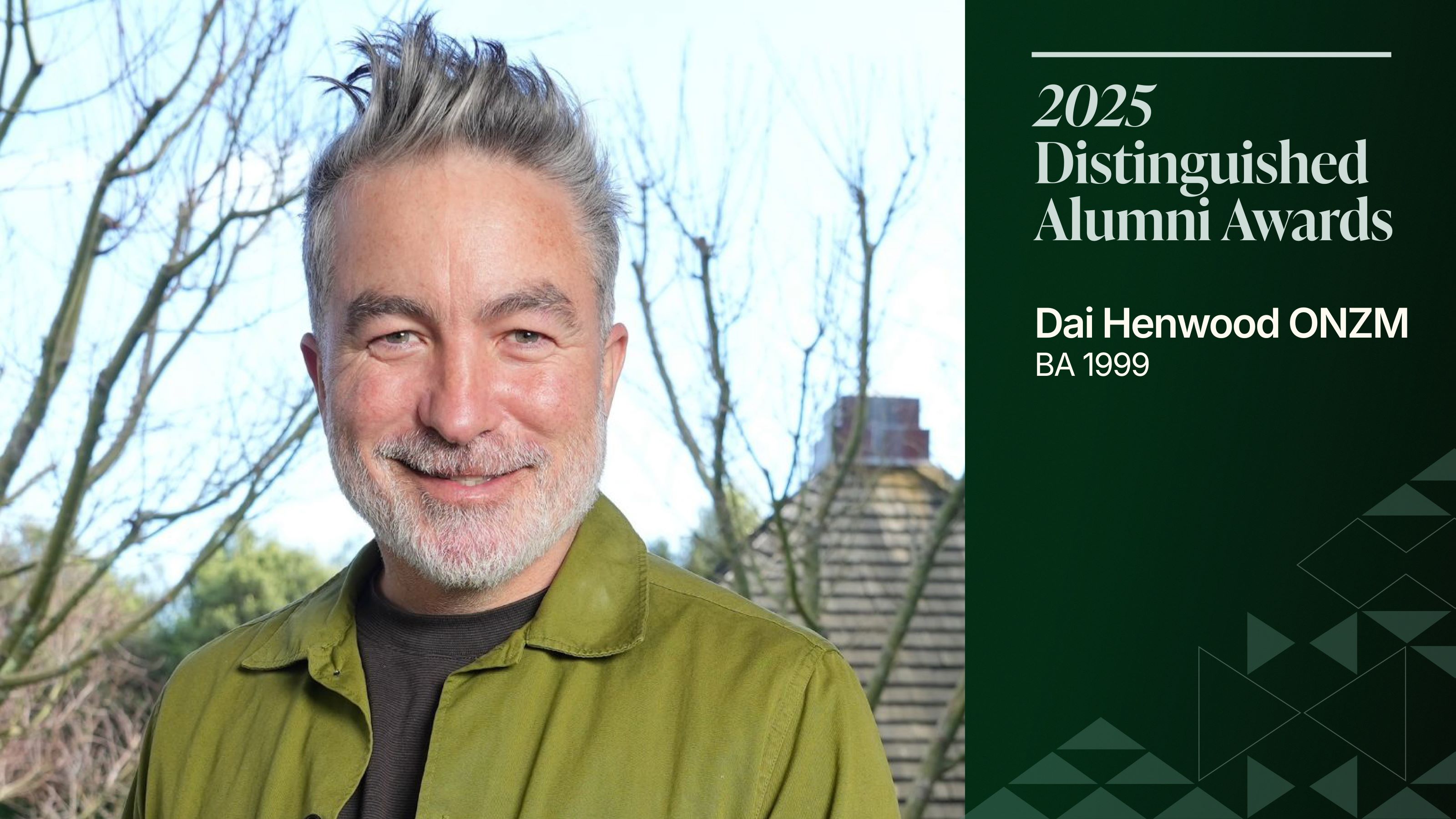 A picture of a smiling middle-aged man in a bright green jacket, in a Japanese garden.