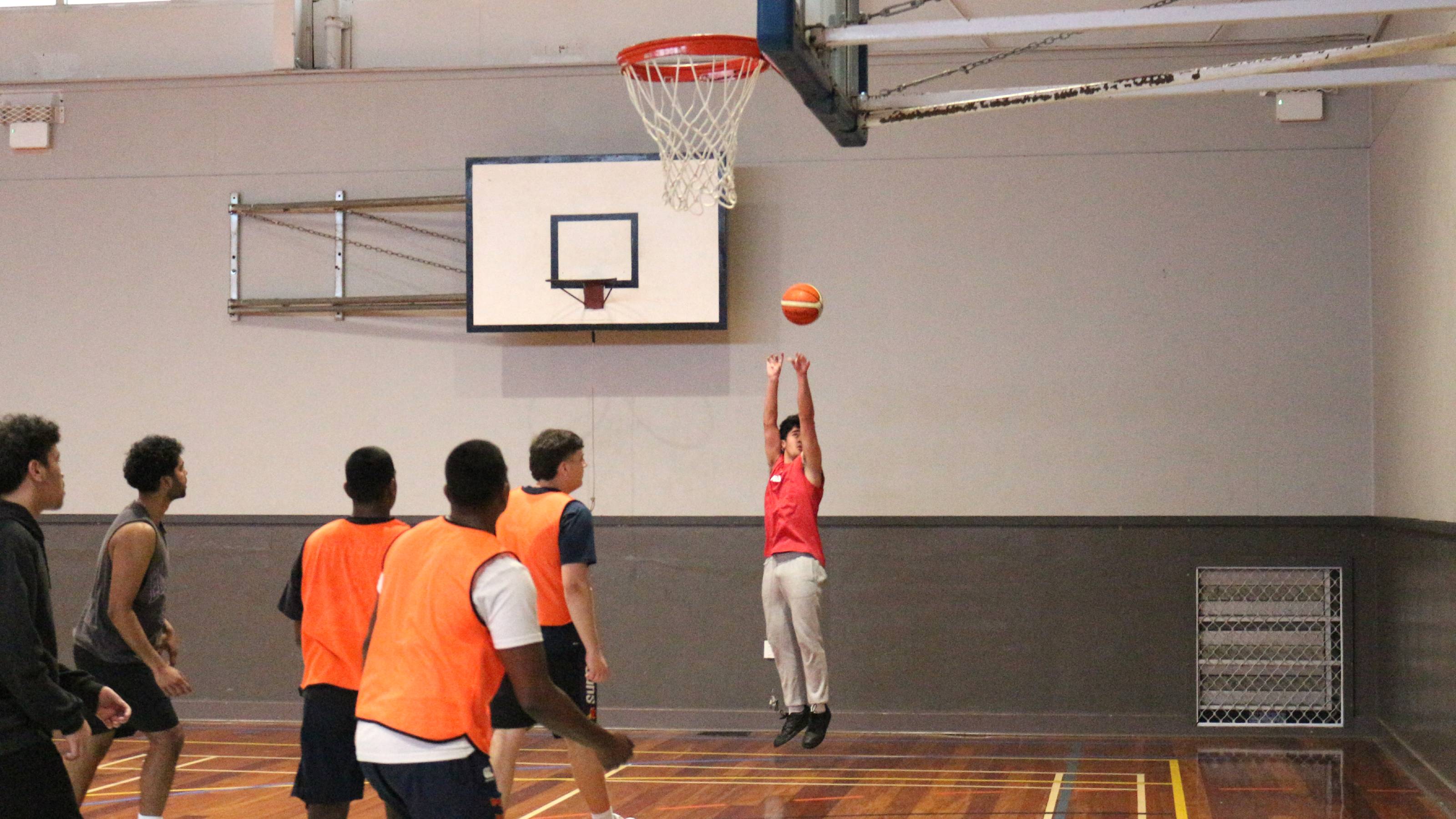 A player dressed in orange jumps for the ball.